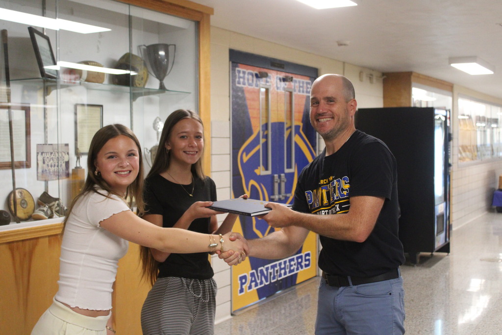 Mr. Birkmeier receives his 2025-2026 copy of the BRHS Yearbook from two students.