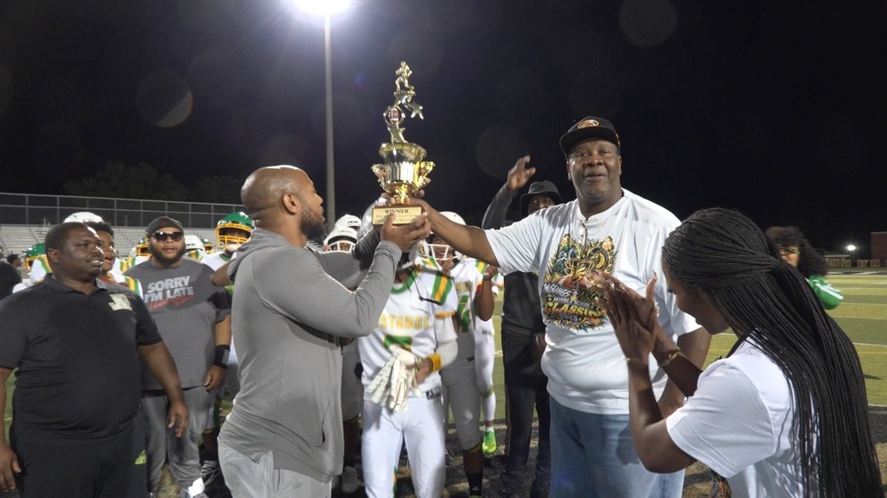 Board Member Walter Wilson hands the Middle School Classic trophy to the Jackson-Olin Mustangs!