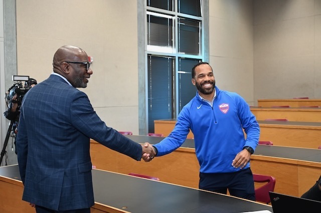 Aubrey Bennett shakes hands with Dr. Mark Sullivan upon learning he has been named Secondary Teacher of the Year for Birmingham City School.