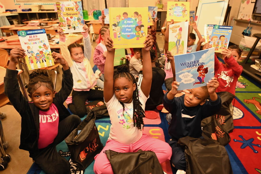 Young readers at Huffman Academy show off newly-donated books