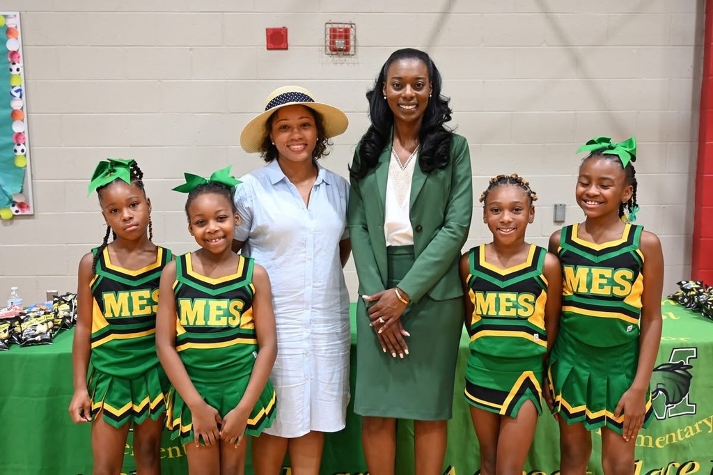 Board Member Sonja Smith and the Minor Cheer Squad pose with Dr. Wiggins