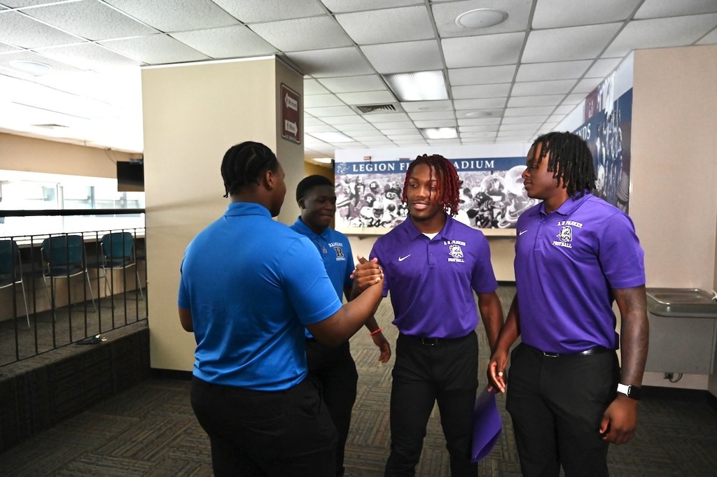 Ramsay's James Reynolds greets Parker's Chancellor Sparks as Ramsay's Jarred Brundidge and Parker's Dylan Reese look on.