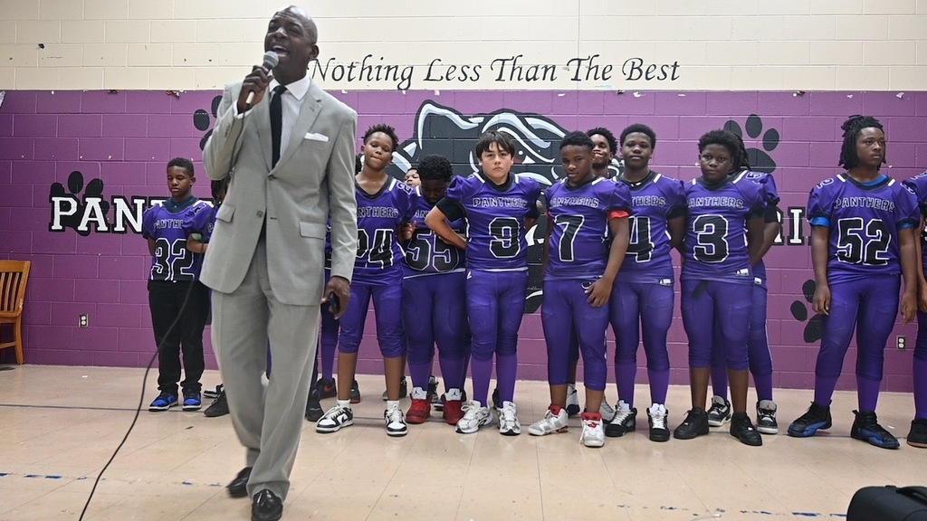 Principal Brown introduces the football team