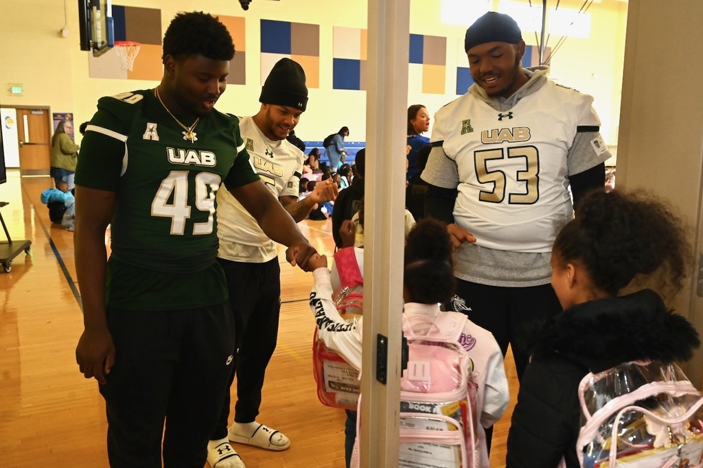 The players greet students