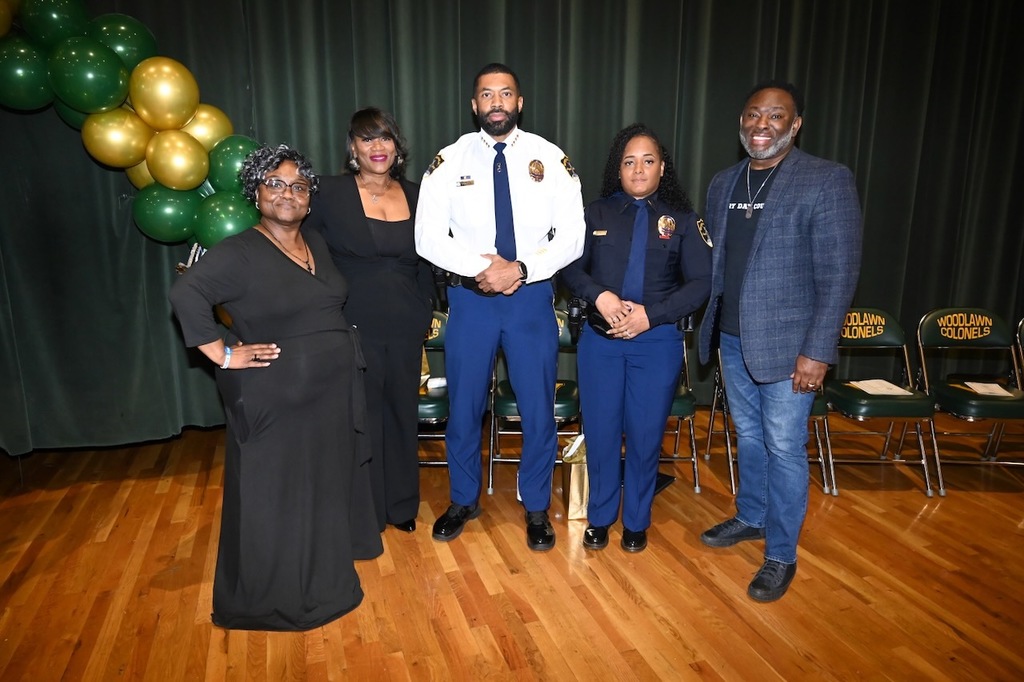 Chief Michael Pickett and Lieutenant Adrienne Powell pose with Principal Rameka Davis (second from left) and Board Member Derrick Billups