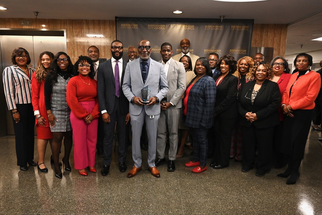 Dr. Mark Sullivan, flanked by Mayor Randall Woodfin, Board President Sherman Collins, and AEA's Lamonica Harris, and surrounded by board and executive cabinet members