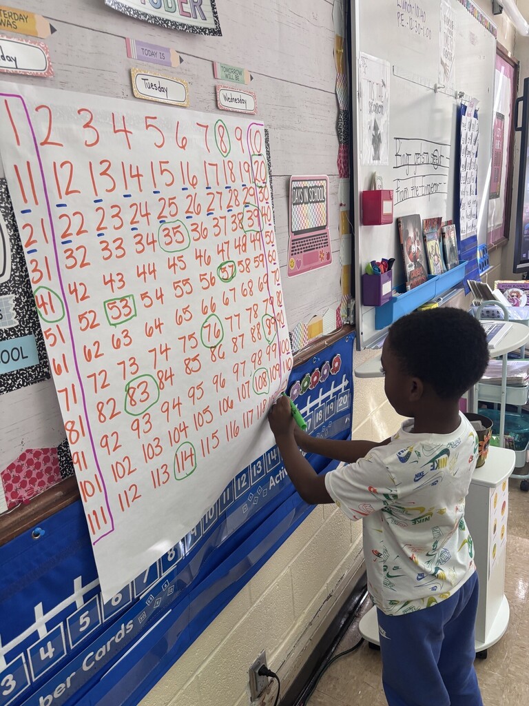 students placing numbers on a 100s chart