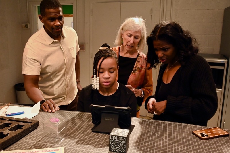 Board member Sherman Collins, Mary Boehm, and Yamika Foy observe an augmented reality demonstration.