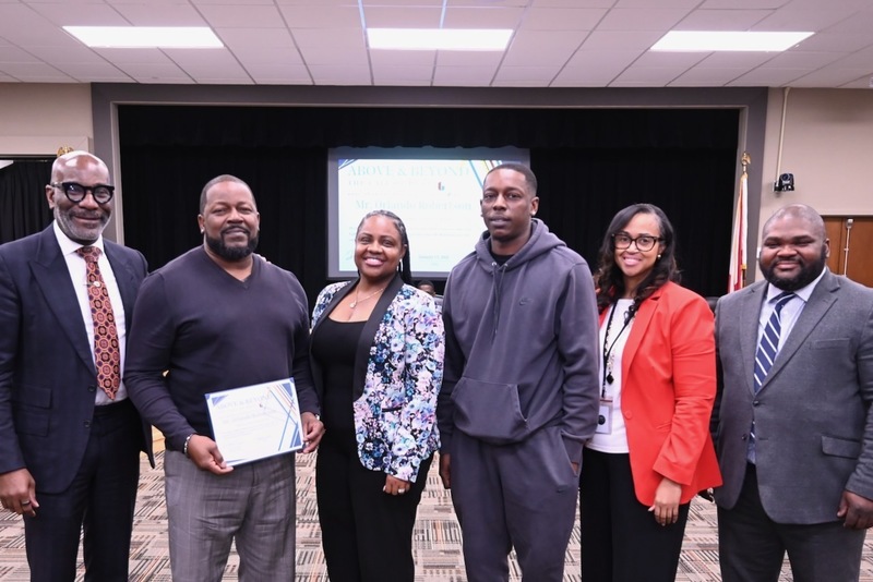 Superintendent Dr. Mark Sullivan, Oscar Robertson and his family, Principal Ja'net Sharpe (in red) and Board Member Antwon Womack