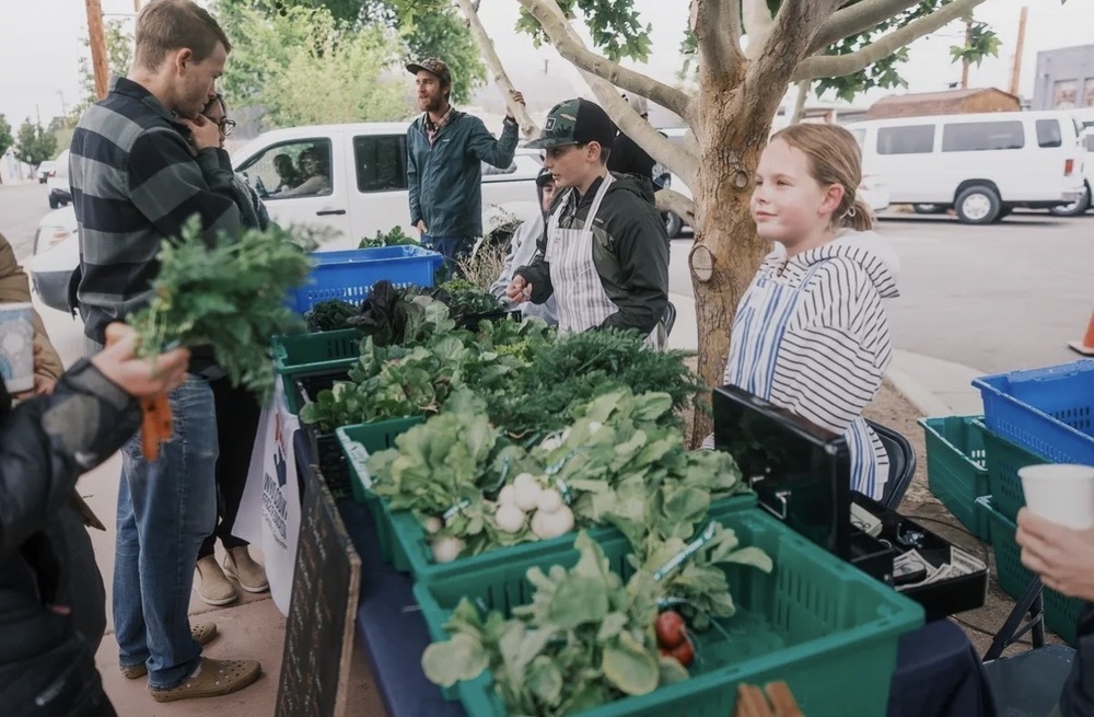 Students sell produce at a farmers market