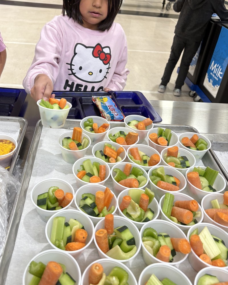 Student grabs a cup of fresh vegetables