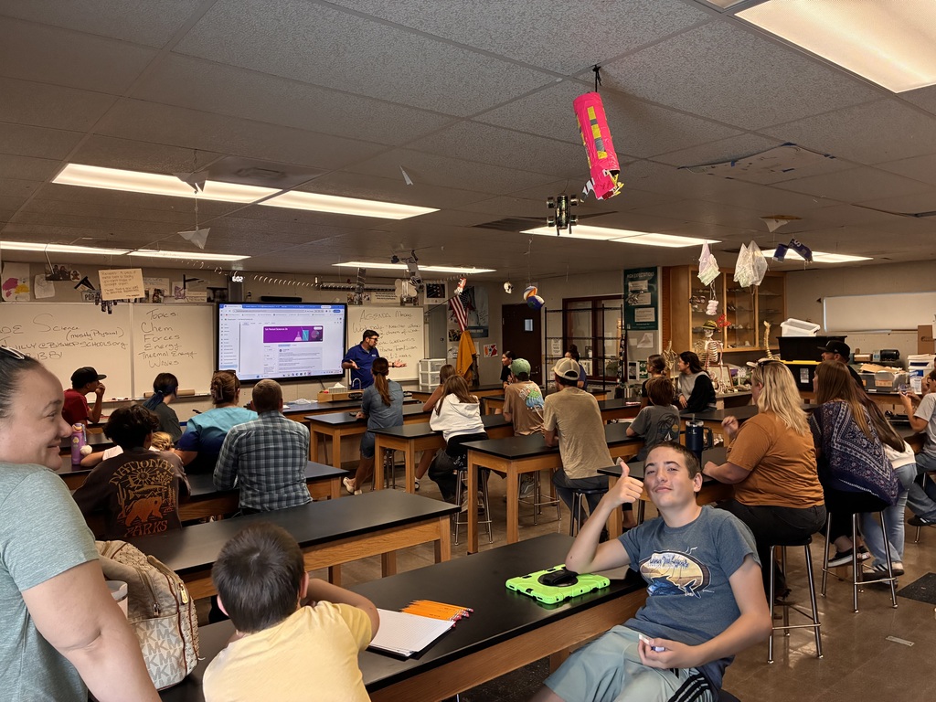 A student gives a thumbs up during a teacher's presentation.