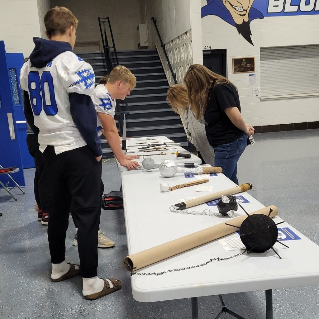 Mrs. Russell asks Ryker D. about his project, a medieval dagger.