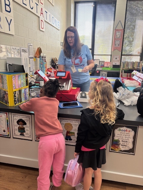 Mrs. Hall checking out Elsie and Kam at the book fair