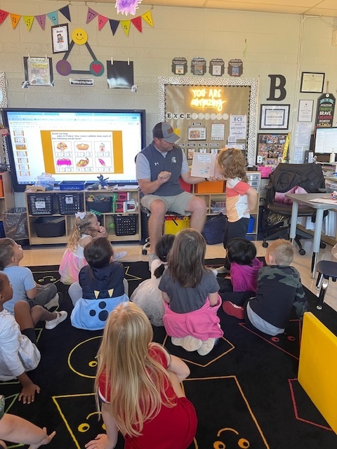 Coach Flowers reads to Mrs. Beach and her friends.