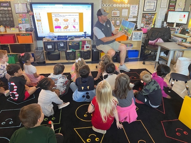 Coach Flowers reads to Mrs. Beach and friends
