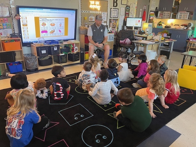 Coach Flowers reads to Mrs. Beach Pre-K friends