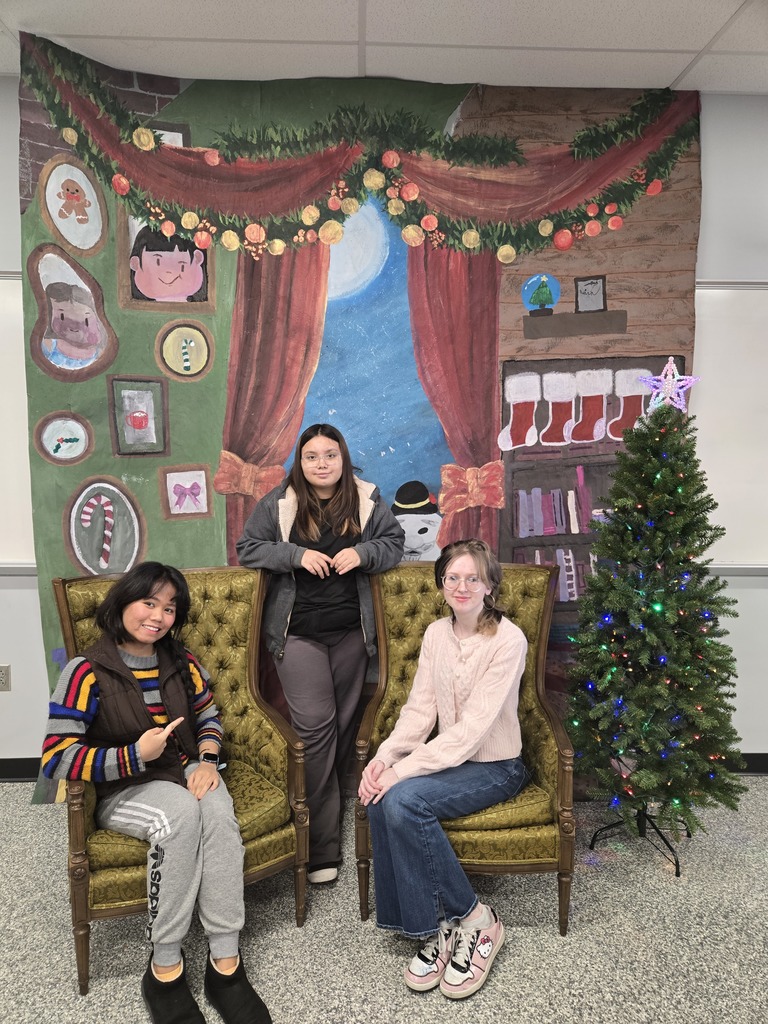 Art students pose in front of the backdrop they created for the Tri-Kappa's Santa Depot