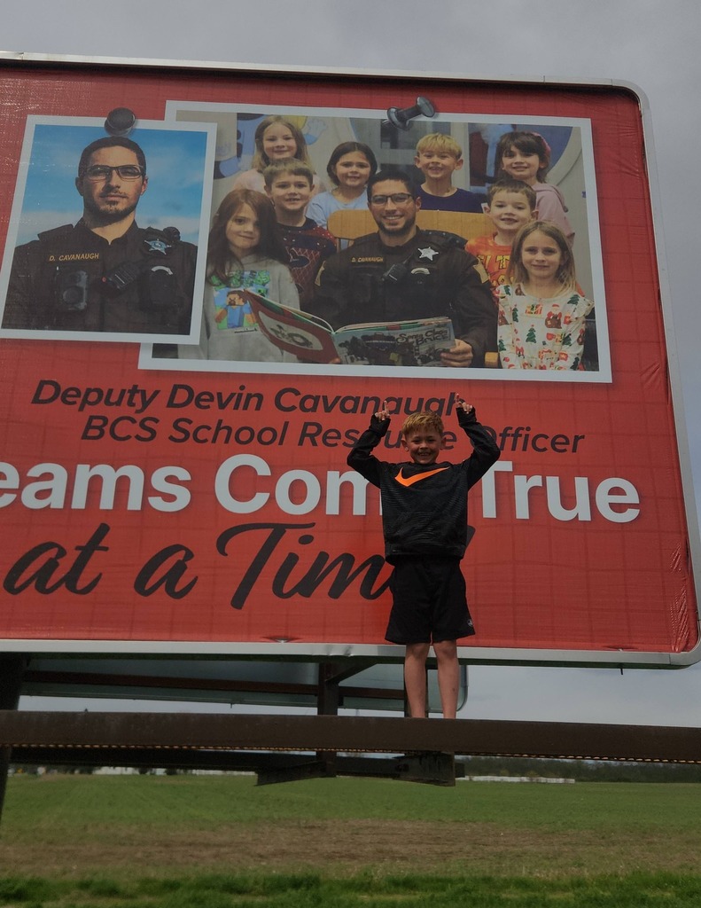 Beu Holdcroft poses before the BCS billboard located on State Road 3 South