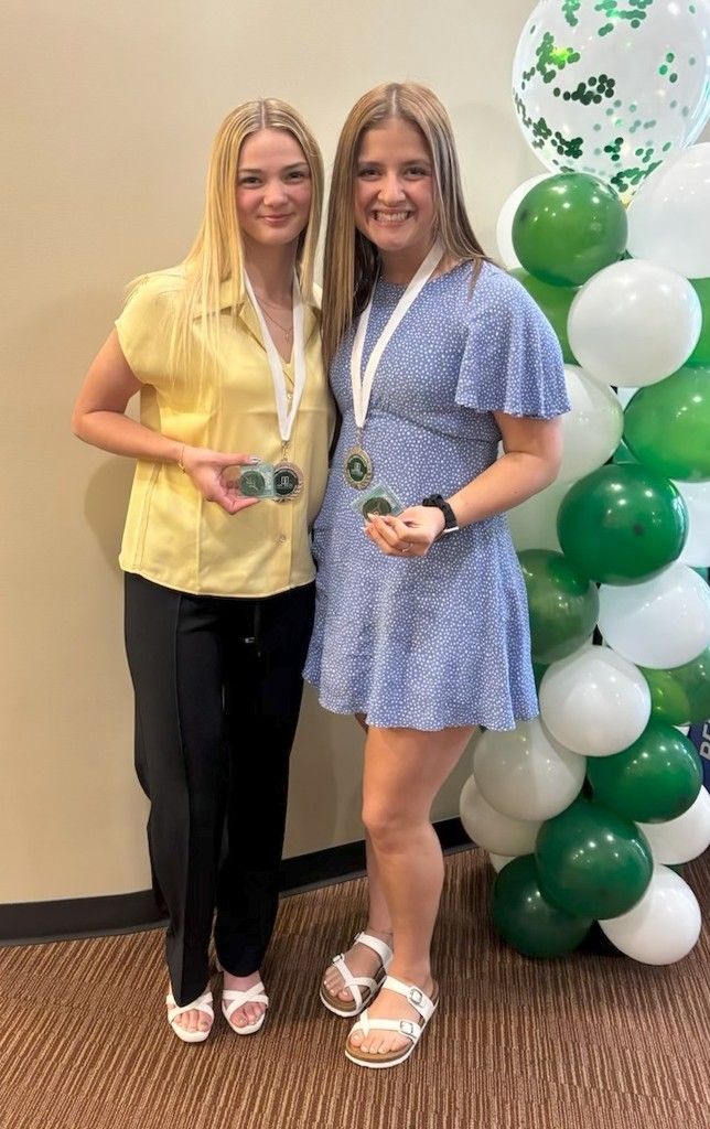 Sara Yoho and Kalli Mealy  pose with their awards after being honored for receiving their Associate Degrees from Ivy Tech