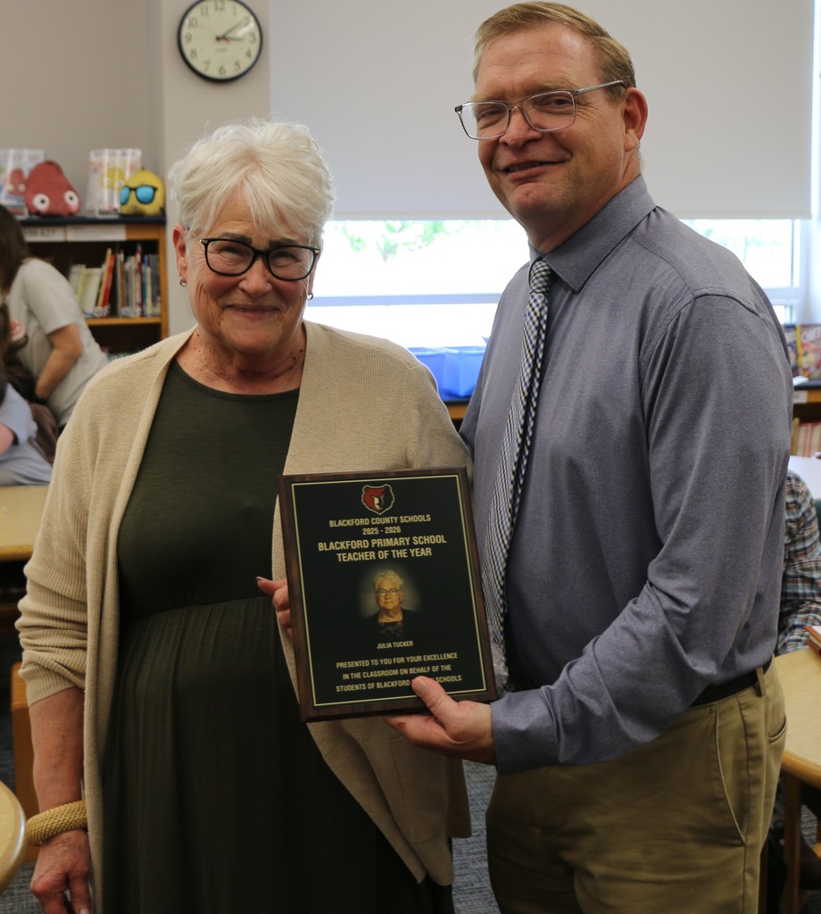 BCS Superintendent Chad Yencer presents Julia Tucker with a plaque honoring her for being named the BPS Teacher of the Year