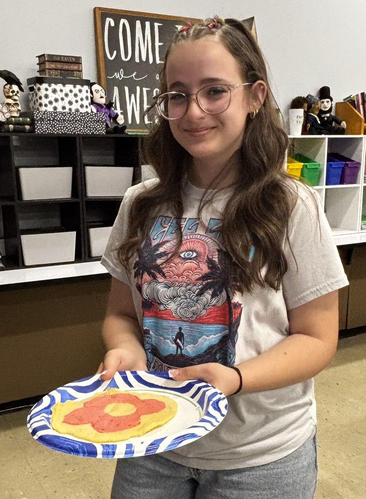 A BJSHS 7th or 8th grade girl shows her pancake art in the shape of a heart