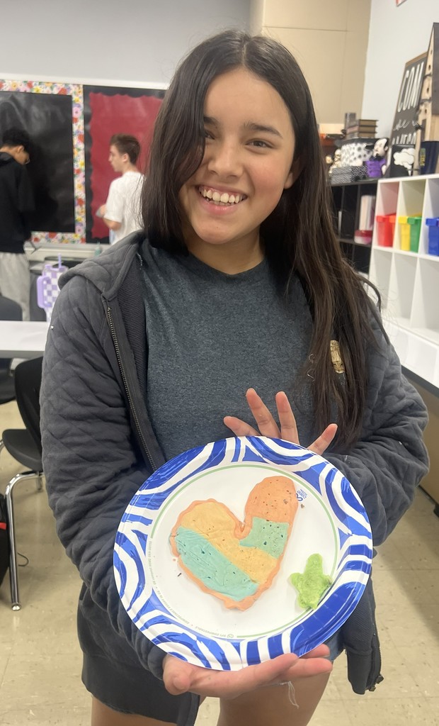 A BJSHS 7th or 8th grade girl shows her pancake art in the shape of a heart