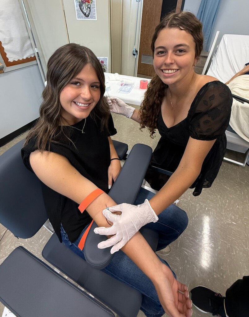 Two BJSHS girls hold demonstrate their medical technique as CNAs.