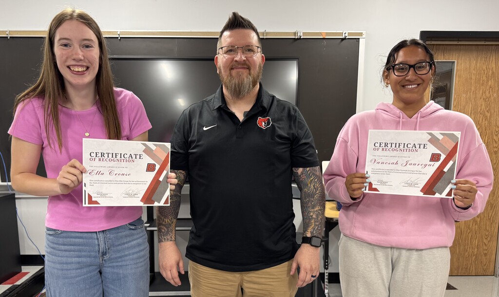 Ella Crouse (left) and Vensah Jaragui join their Criminal Justice Instructor Mike Jones for an award