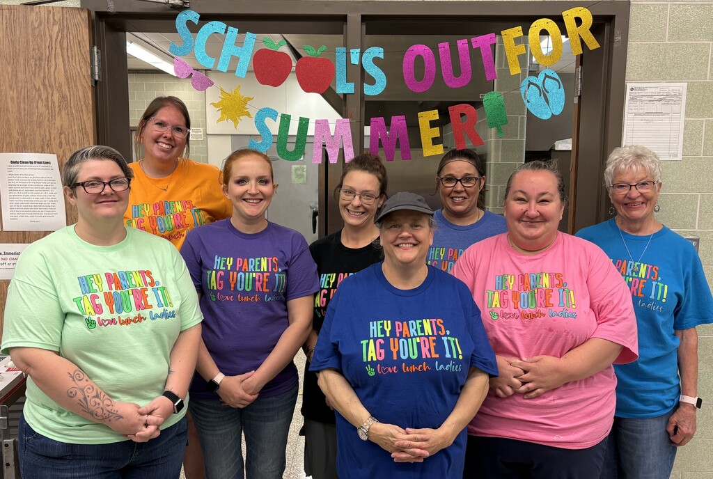 The 8 lunch ladies from BJSHS pose before a School Is Out For Summer poster