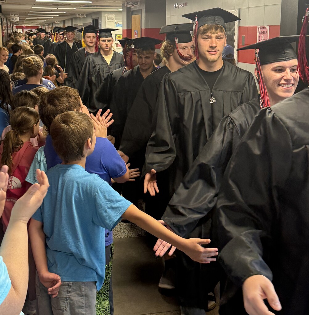 BJSHS seniors walk in their caps and gowns down the halls of BIS and BPS