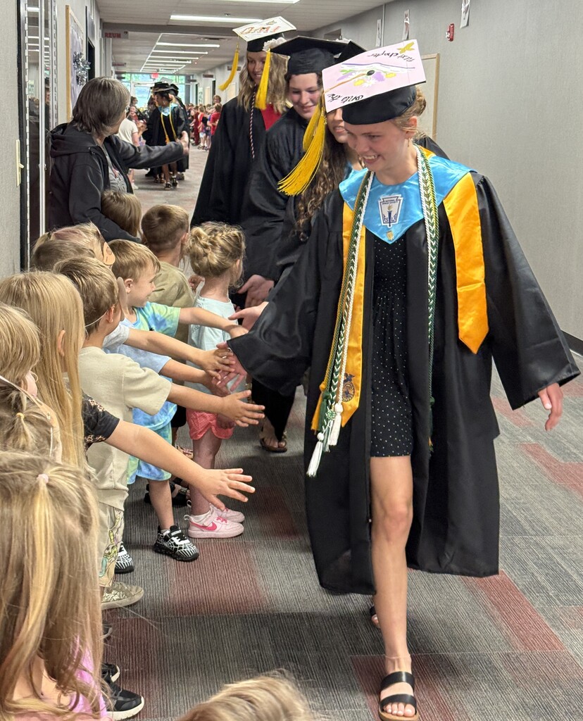 BJSHS seniors walk in their caps and gowns down the halls of BIS and BPS