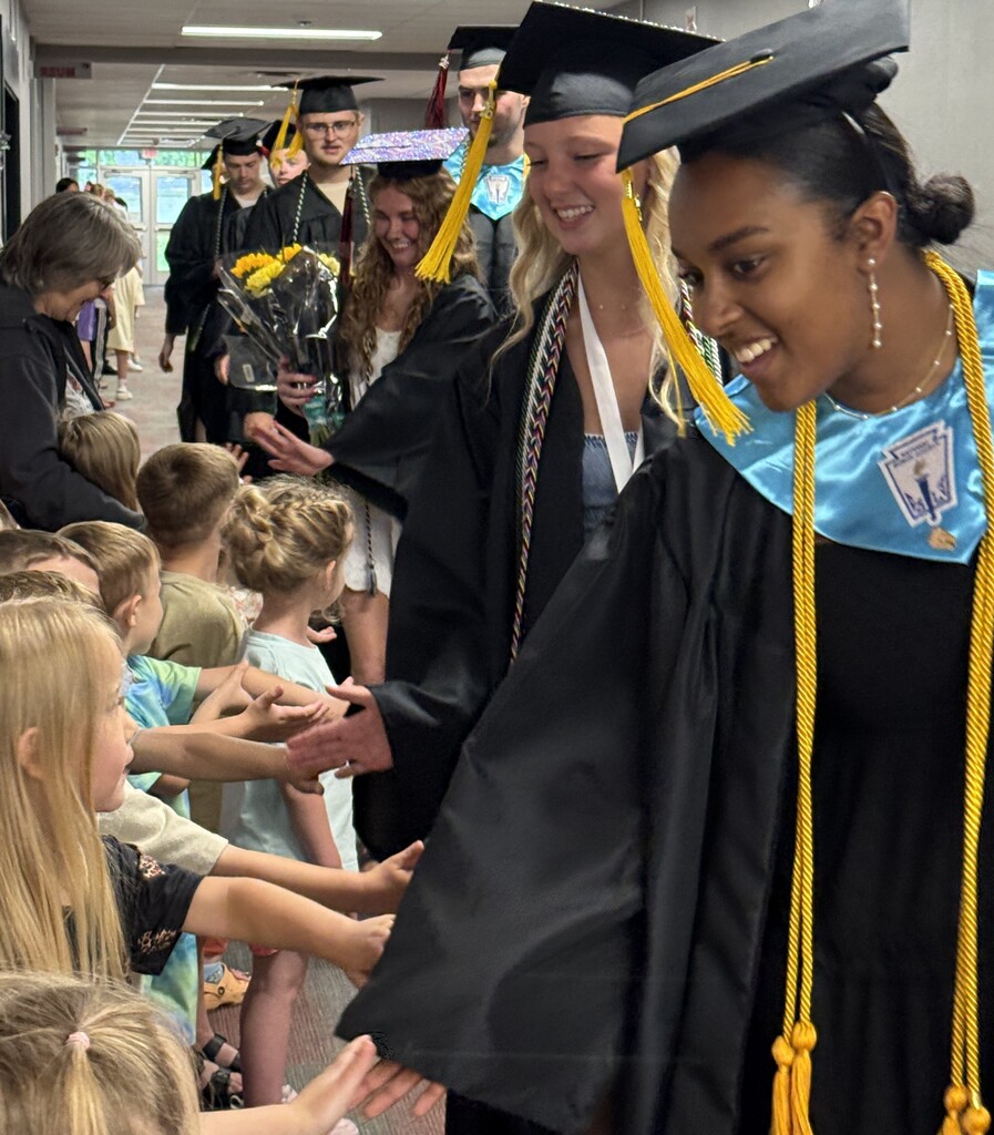 BJSHS seniors walk in their caps and gowns down the halls of BIS and BPS