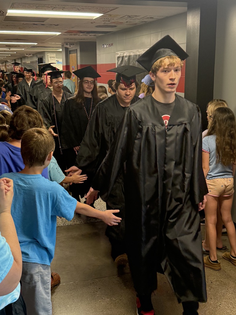 BJSHS seniors walk in their caps and gowns down the halls of BIS and BPS