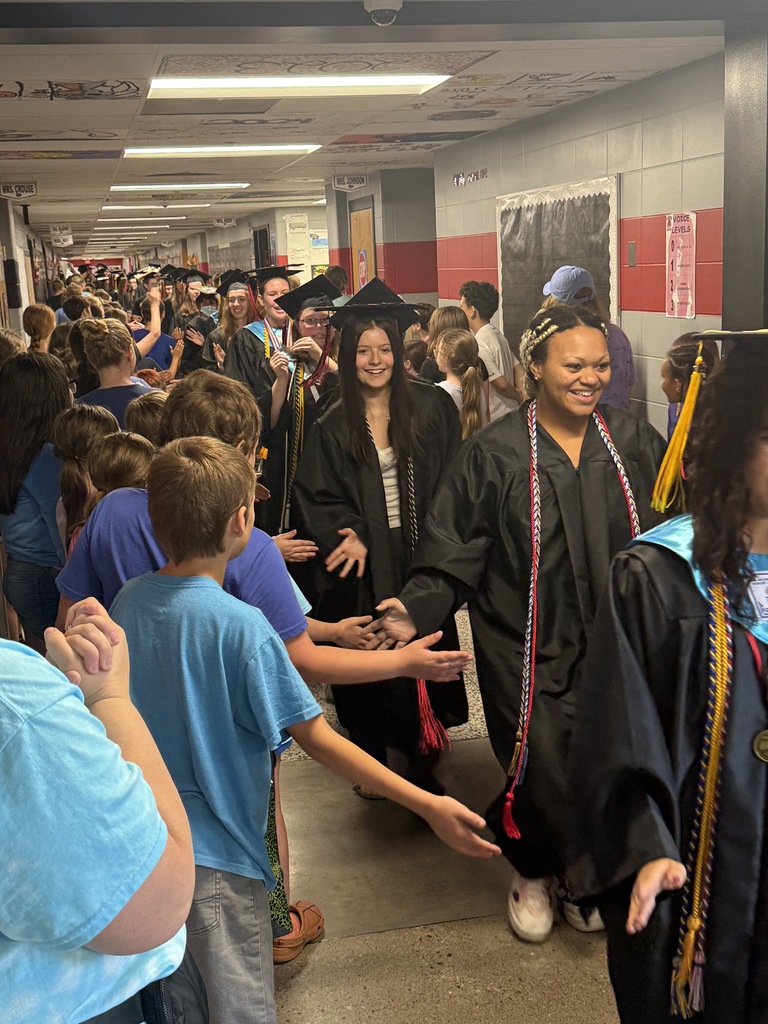 BJSHS seniors walk in their caps and gowns down the halls of BIS and BPS