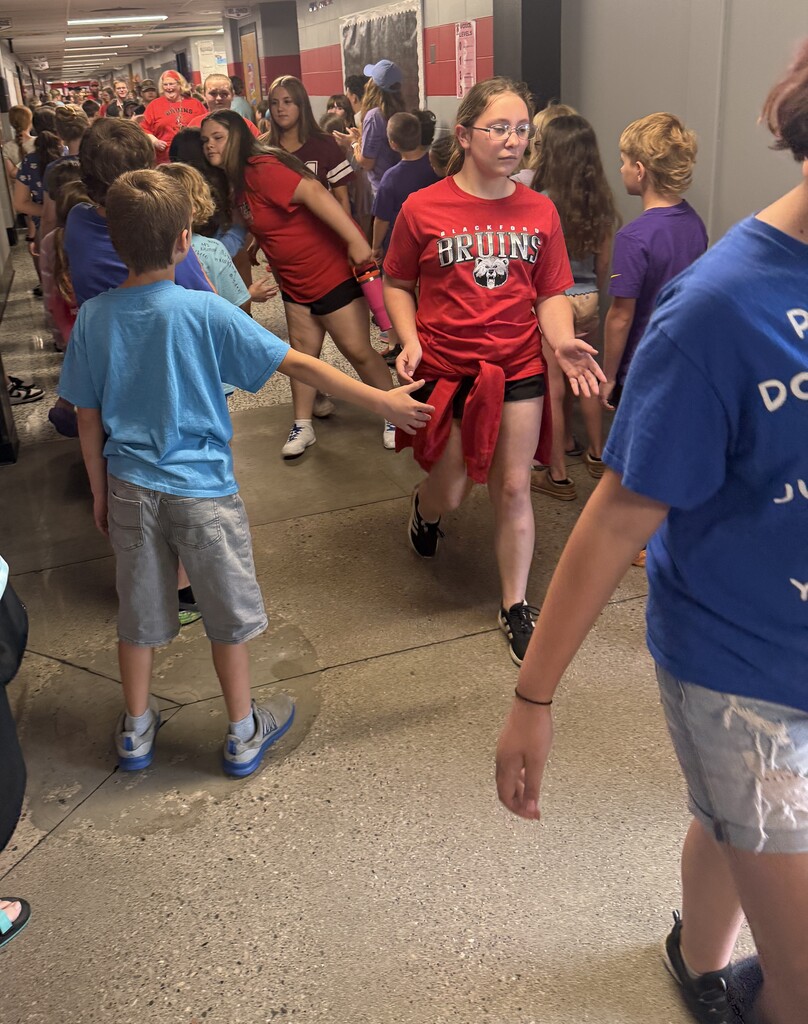 A 6th grade girl leads the procession of 6th grade students being congratulated at the BIS