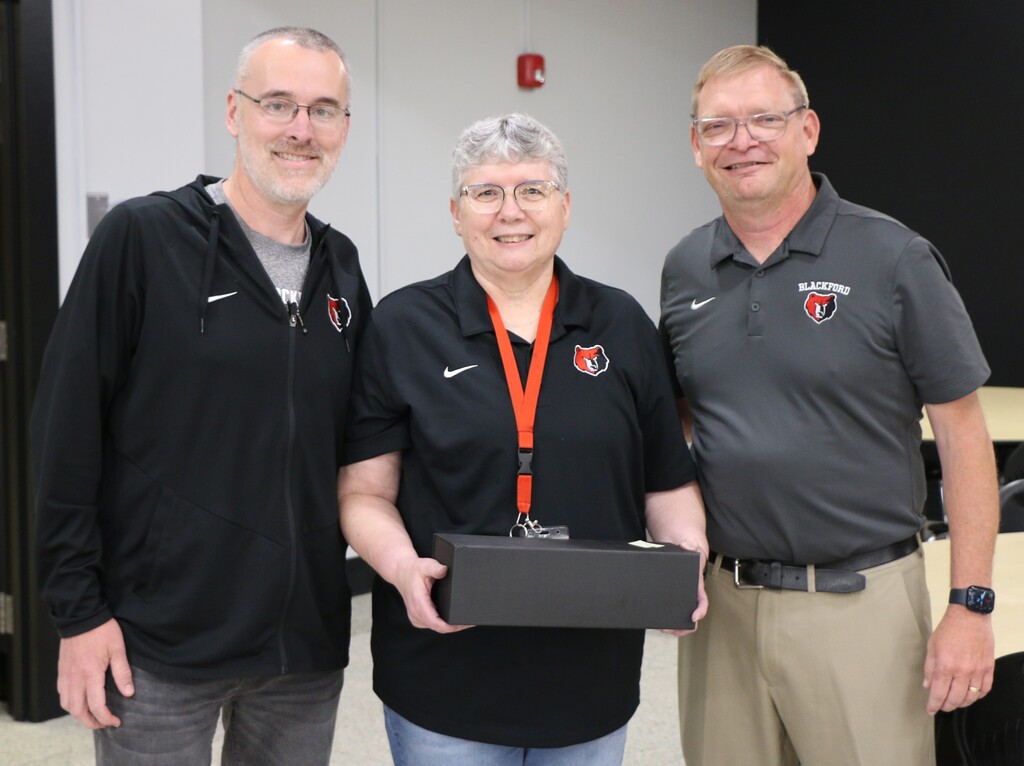 Linda Wallace accepts her retirement award from (left) BJSHS Principal Jason Ridge and BCS Principal Chad Yencer