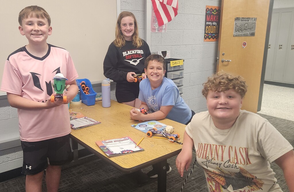 3 boys and 1 girl pose for a photo during Camp Invention