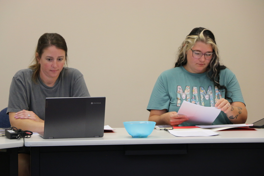 Two new BCS employees look over their paperwork during a back to school meeting