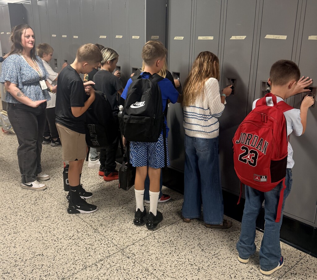 Students work their locker combinations during the first day of school