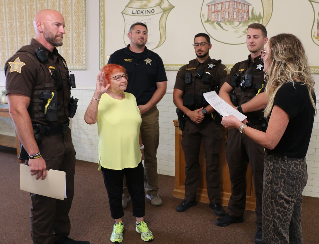 Kim Pitts swears in Doris Wilson as the Blackford County officers look on.