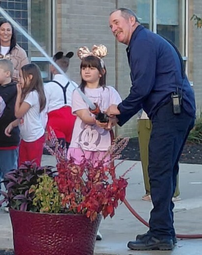 A girl took turns holding the fireman's fire hose during fire safety lessons at BPS