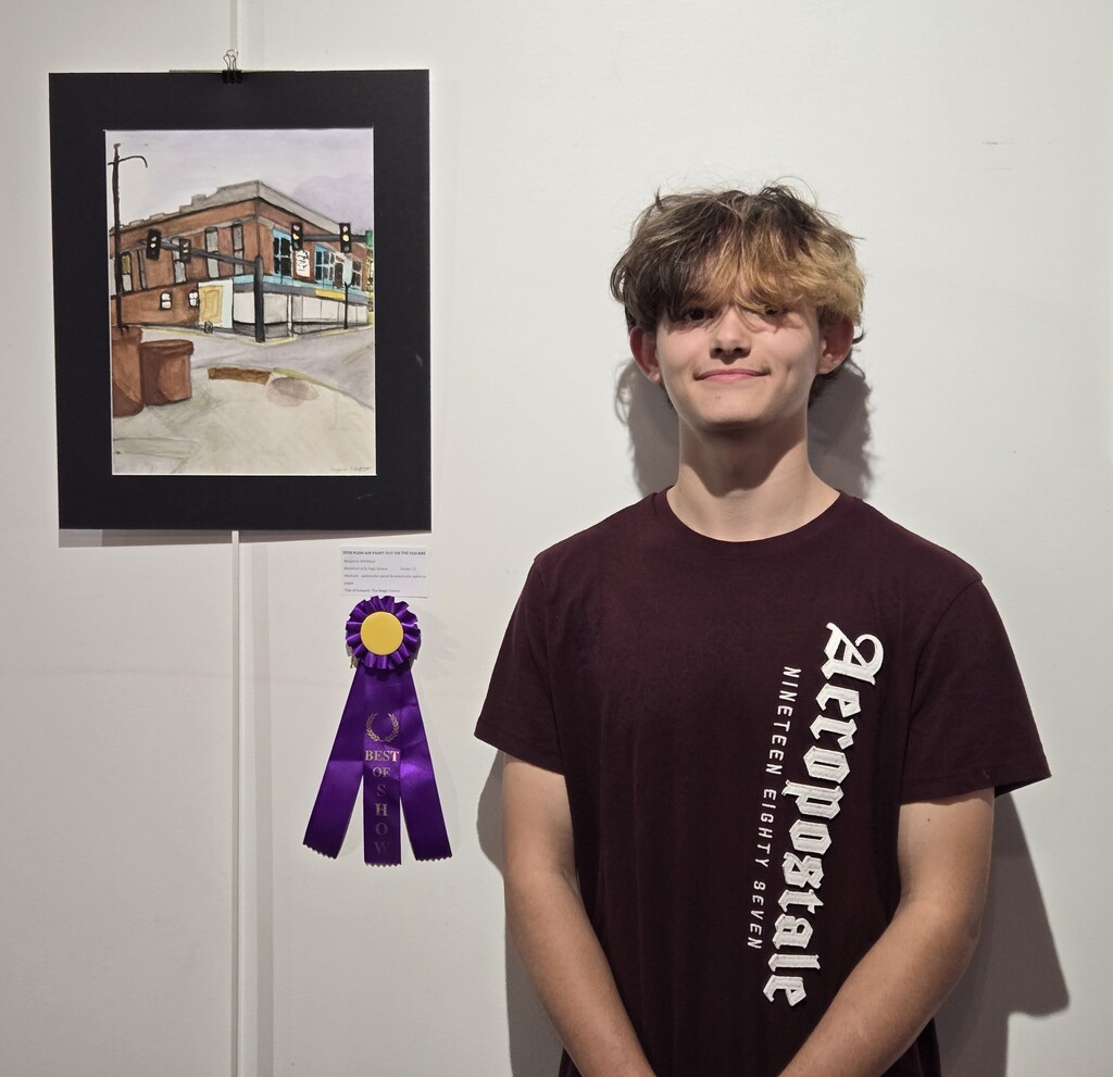 Benjamin Whitfield stands beside his Best of Show painting for the 2026 Plein Air Paint Out on the Square exhibition