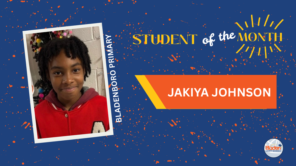  Portrait of Bladenboro Primary Student of the Month, Jakiya Johnson, smiling and wearing a red jacket, standing against a classroom wall, displayed on a blue Bladen County Schools recognition graphic.