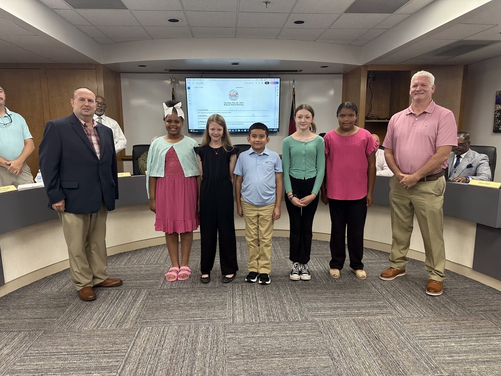 photo of Bladen Lakes Primary School—Leonardo Alvarado, Cailyn Knuth, Ava Dorsett, Olivia Burton, and Zoe Skinner with Superintendent Jason Atkinson and BOE Chair Mackie Singletary