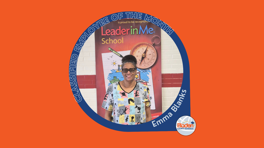 Graphic announcing Classified Employee of the Month featuring Emma Blanks, smiling while standing in front of a Leader in Me school display, wearing glasses and a patterned top, with Bladen County Schools logo.