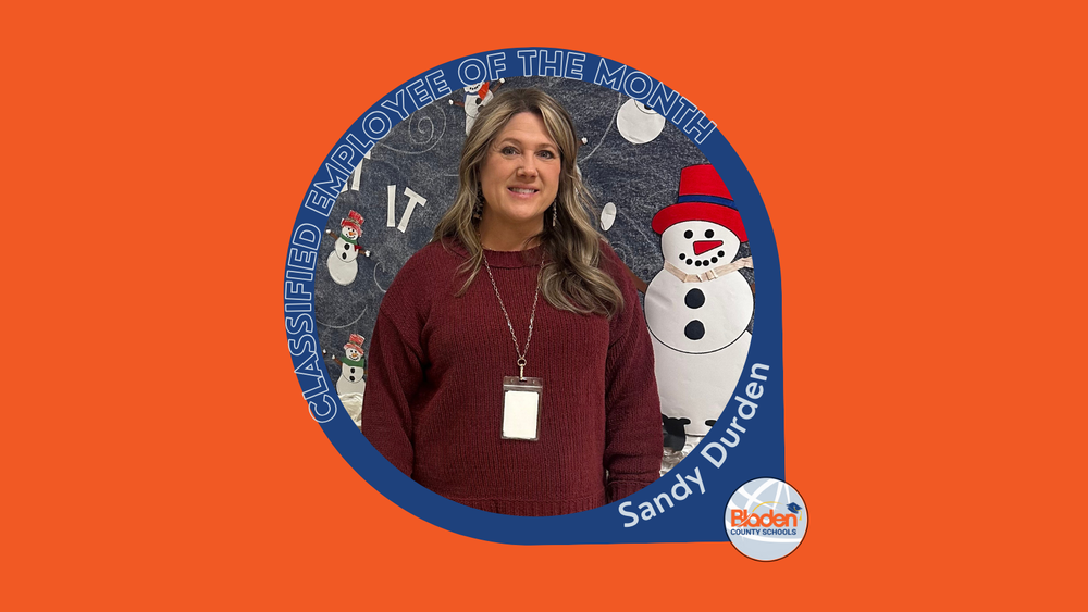 Graphic announcing Classified Employee of the Month featuring Sandy Durden, smiling while standing in front of a winter-themed classroom display with snowmen, wearing a maroon sweater and ID badge, with Bladen County Schools logo.