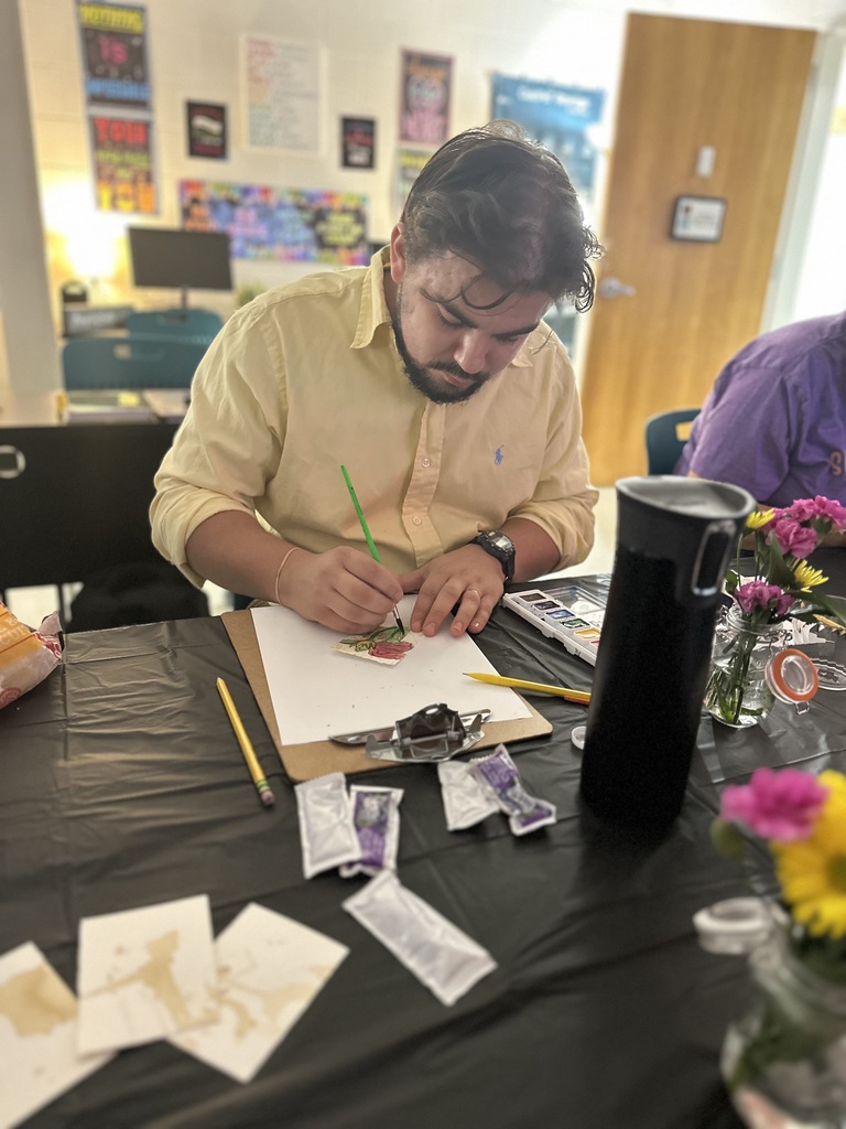 Man painting with watercolors on a clipboard.