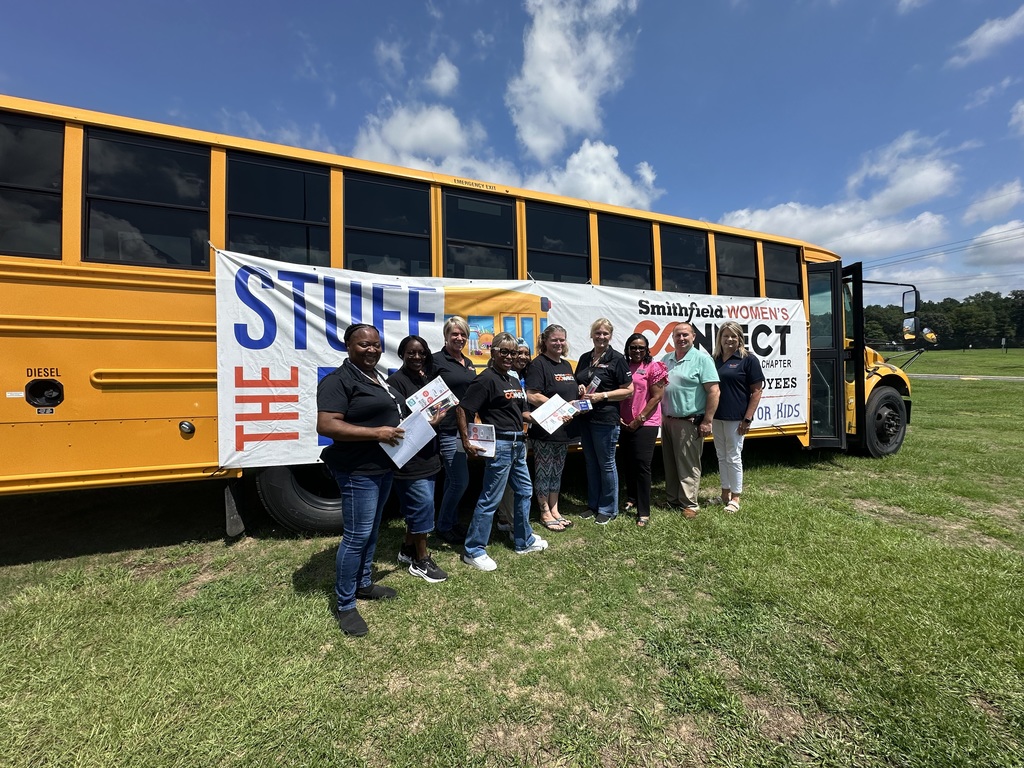 Smithfield Women’s Connect Tar Heel Chapter and employees donate school supplies by a bus.