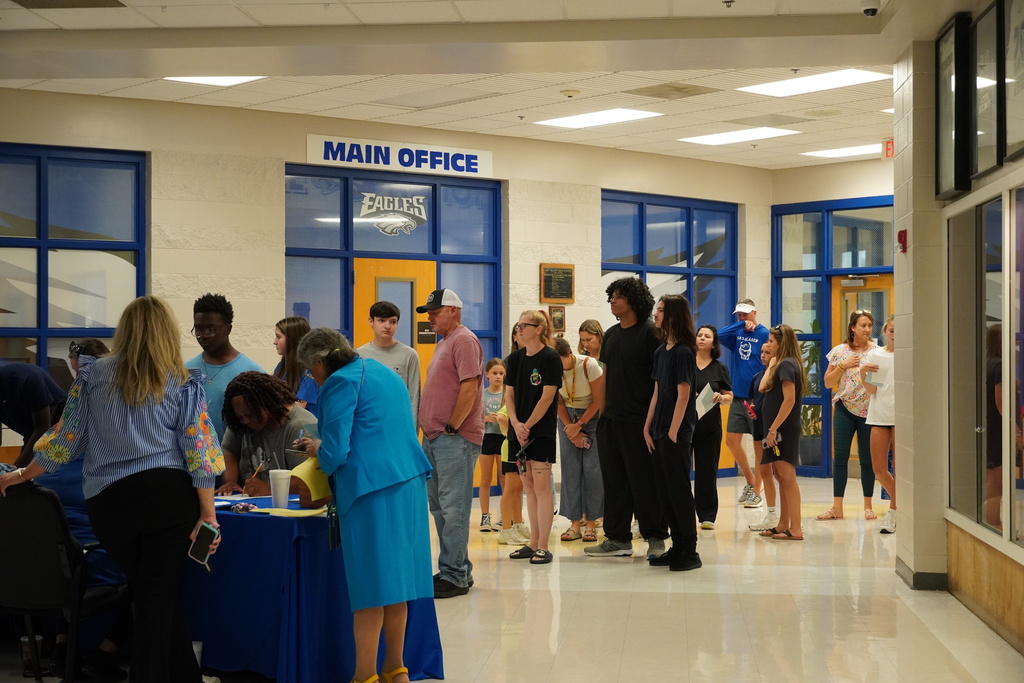 Families and students line up at the main office during orientation check-in.